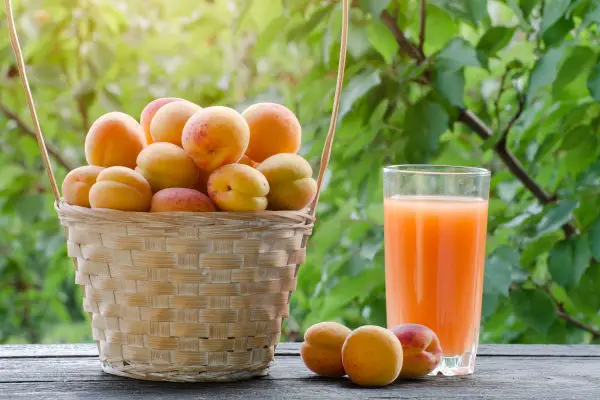 Apricots in a wicker basket and a glass of juice