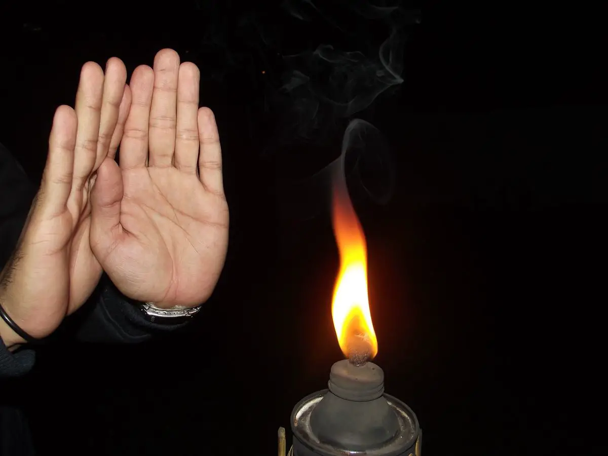 Hands warming near a flame.
